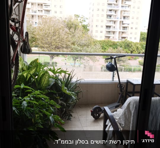 מבט למרפסת מרוהטת ומוצלת דרך פתח דלת הזזה